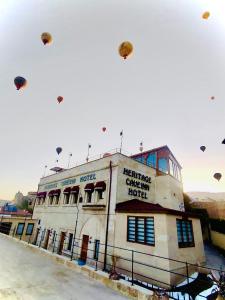 a group of kites flying over a building at Heritage Cave Inn Hotel in Avanos