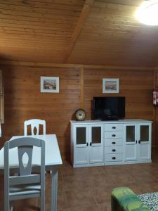 salon ze stołem i telewizorem oraz stołem i krzesłem w obiekcie Apartamentos Rurales Sierra Luna w mieście Andújar