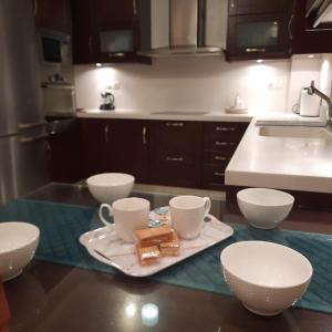 uma cozinha com uma bandeja com duas chávenas e um leilão em Family Comfortable Spacious Apartment em Heraclião