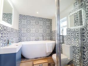 La salle de bains est pourvue d'une baignoire, d'un lavabo et de toilettes. dans l'établissement Wherry Cottage, à Manningtree