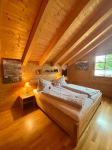um quarto com uma cama grande num quarto de madeira em Damülser Holzhus em Damüls