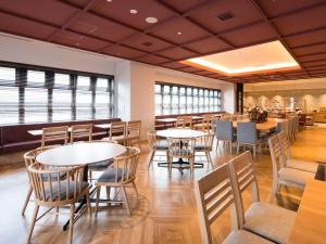 a dining room with tables and chairs and windows at GRIDS PREMIUM HOTEL OTARU in Otaru