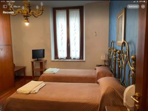 Zimmer mit 3 Betten und einem Fenster in der Unterkunft B&B In Liberty Style in Settimo Milanese