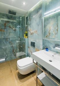 La salle de bains est pourvue de toilettes et d'un lavabo. dans l'établissement SUN RESIDENCE Exclusive Seaside Suites, à Polychrono