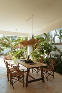 a dining room with a wooden table and chairs at Kuwa Zanzibar in Kiwengwa