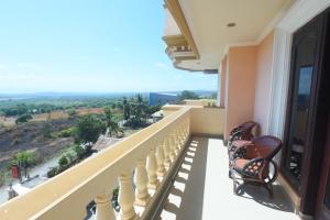 a balcony with chairs and a view of the valley at CHRYSANT HOTEL & RESORT in Oesapa-besar