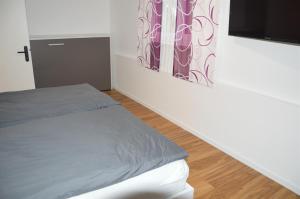 a bedroom with a bed and a tv on a wall at Seedomizil Gaisrücken in Pörtschach am Wörthersee