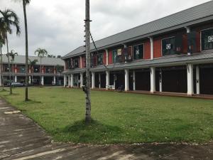 a building with a tree in the middle of a field at The nearest Surattani airport in Suratthani