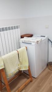 eine Waschküche mit einer Waschmaschine und 2 Stühlen in der Unterkunft Lar do solpor in Allariz