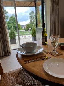 a table with a bottle of wine and a glass at Award Winning Lodge at Ewen Barn, Ewen, Cirencester in Cirencester