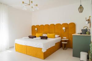 a bedroom with a large wooden bed with yellow pillows at Style rooms Split in Split