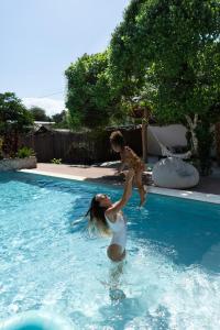 a woman and a child jumping into a swimming pool at Kuwa Zanzibar in Kiwengwa