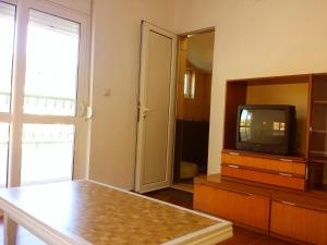 a living room with a tv and a mirror at Hoxha rooms in Ulcinj