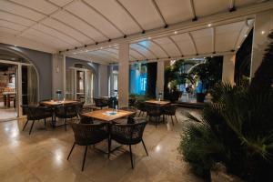 um restaurante com mesas e cadeiras num edifício em Hotel Palma em Tivat