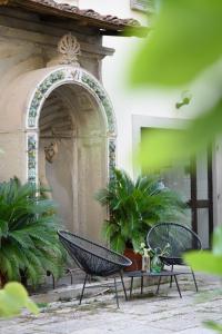 2 sillas y una mesa en una habitación con plantas en La Gabbia del Grillo, en Florencia