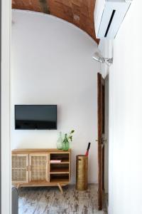 een woonkamer met een televisie aan een witte muur bij La Gabbia del Grillo in Florence