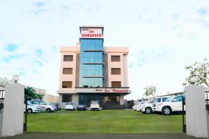 un edificio con coches estacionados en un estacionamiento en Hotel Sai Ramanand, en Shirdi