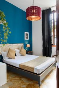 1 dormitorio con 1 cama grande y pared azul en La Gabbia del Grillo, en Florencia