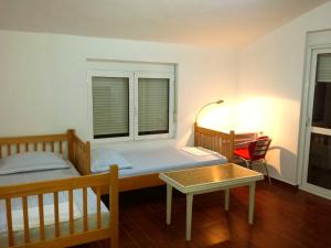 a bedroom with a bed and a table and a window at Hoxha rooms in Ulcinj