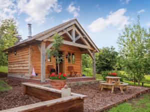 a small log cabin with a picnic table and a picnic table at Copperbeech Bowtop in Tilston