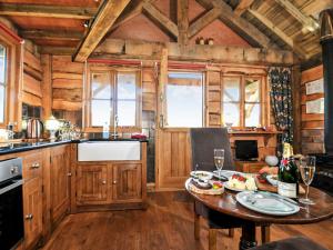 a kitchen with wooden cabinets and a table in a cabin at Copperbeech Bowtop in Tilston