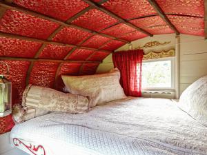 łóżko w pokoju z czerwonym sufitem w obiekcie Copperbeech Bowtop w mieście Tilston