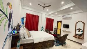 una camera con letto, specchio e tende rosse di PETAL OF MEWAR - A Luxury Boutique Hotel a Udaipur