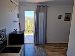 a kitchen with a large window with a view at Hari Apartments Vathi, Agios Nikolaos Crete in Vathi