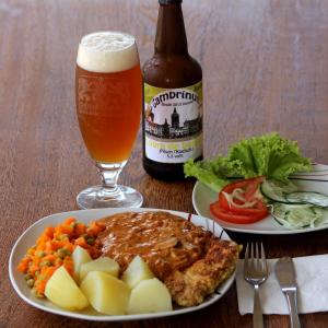 ein Tisch mit einem Teller Essen und einem Glas Bier in der Unterkunft Tabatinga Relax Apartamentos in Conde + 51 Fotos