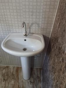 a white sink in a white tiled bathroom at Makratela in Akhmety