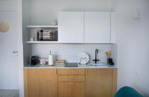 uma cozinha com armários brancos e um lavatório em Il Grande Blu em Terracina