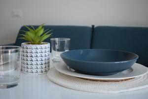 una mesa con un tazón azul y platos y vasos en Il Grande Blu, en Terracina