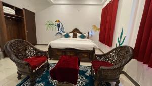 PETAL OF MEWAR - A Luxury Boutique Hotel في أودايبور: غرفة نوم بسرير مع كرسيين وسرير