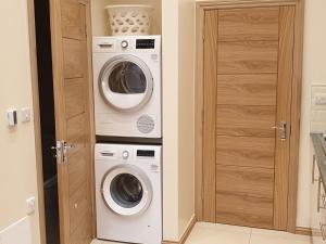 a laundry room with a washer and dryer at London Luxury Studio Flat 4 min to Ilford Station with FREE parking FREE WiFi in Ilford