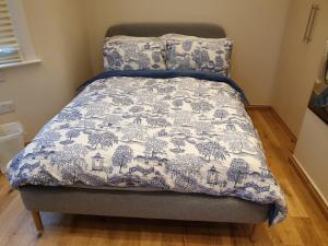 een bed met een blauwe en witte deken erop bij London Luxury Studio Flat 4 min to Ilford Station with FREE parking FREE WiFi in Ilford