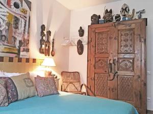 a bedroom with a blue bed and a large wooden cabinet at La Rosa del Deserto, Versilia in Marina di Massa