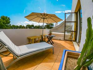 eine Terrasse mit einem Bett und einem Sonnenschirm in der Unterkunft Boutique Hostal La Curandera de Salinas in Ibiza-Stadt