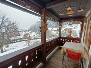 a balcony with a table and chairs and a snow covered mountain at Oberweinfeld in Berchtesgaden