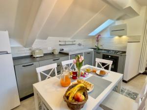 - une cuisine avec une table et une corbeille de fruits dans l'établissement Happy Family Apartments The Roof, à Gênes