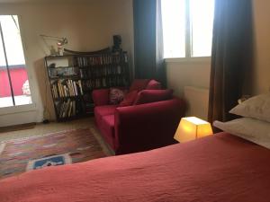 un soggiorno con divano rosso e sedia di La casa rossa a Saint-Riquier-ès-Plains