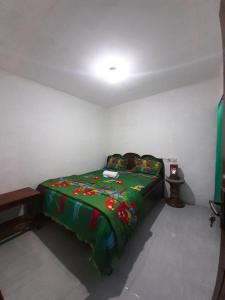 um quarto com uma cama com um cobertor verde em Tetebatu Sunrise Homestay em Tetebatu