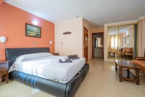 a bedroom with a large bed and a living room at Hotel Velis - Avenida I in Vélez-Málaga