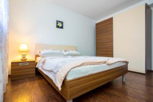 um quarto com uma cama grande e uma cabeceira em madeira em Apartmani Sandra Malinska em Sveti Vid-Miholjice