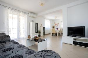 salon z kanapą i telewizorem w obiekcie Apartmani Sandra Malinska w mieście Sveti Vid-Miholjice