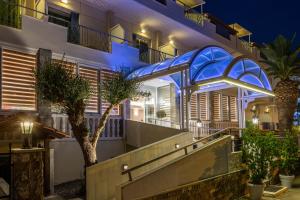 un edificio con una fachada iluminada en azul por la noche en Hotel Serenity Tolo en Tolón