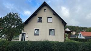 a white house with a black roof at Ferienwohnung am Bakenberg in Hahausen