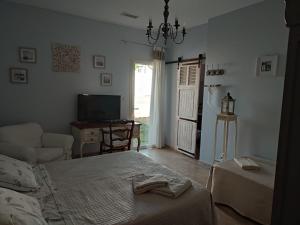 um quarto com uma cama, uma televisão e uma cadeira em les olivades em Magalas