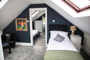 The Charlton Boutique Hotel في تشلتنهام: غرفة نوم في العلية مع سرير ومرآة