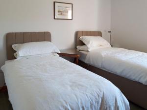 two beds sitting next to each other in a room at Lismore Cottage in North Ballachulish