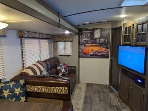 a living room with a couch and a flat screen tv at American Rv - Dog friendly - Peaceful location in Sutton on Sea